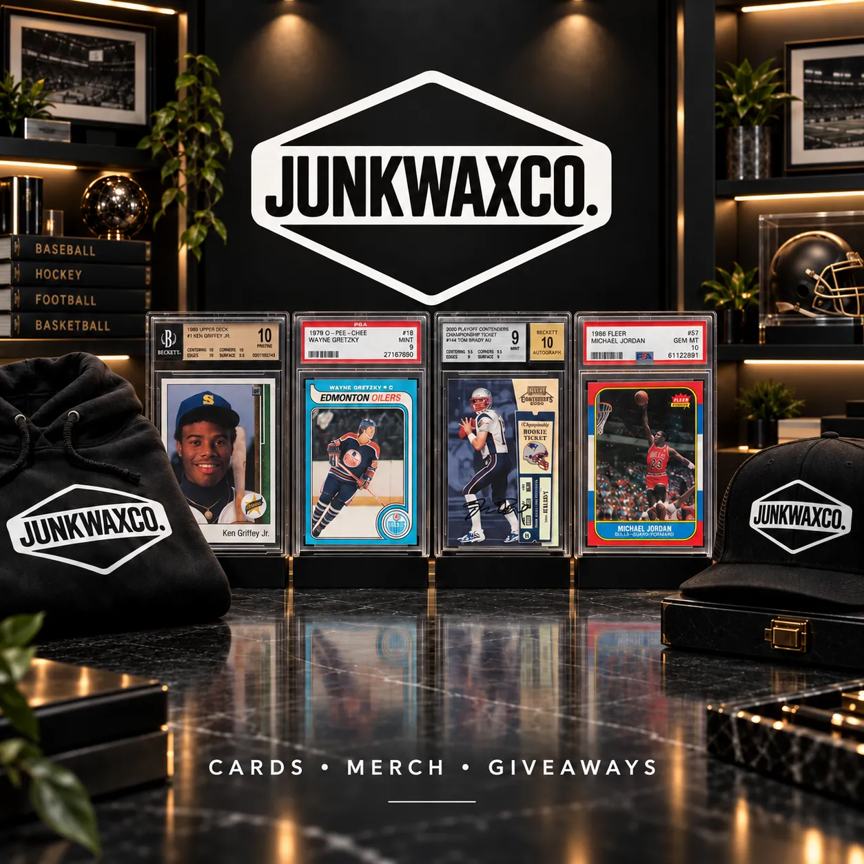 Junkwaxco display of graded sports card slabs alongside branded hoodie and cap